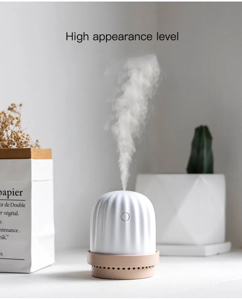 Cactus humidifier night light in green with colourful LED glow on a wooden desk