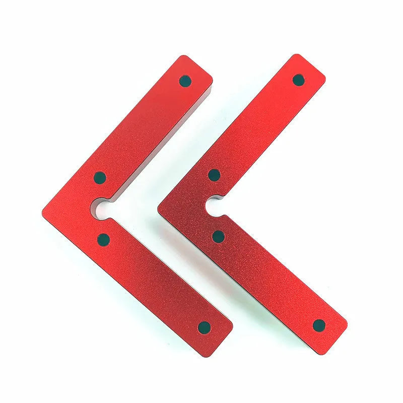 Silver aluminium right angle block clamped to a wooden workbench next to a jigsaw, showing scale markings.
