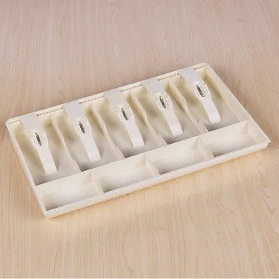 Black and white ABS plastic cash register box with five drawers for banknotes and coins.