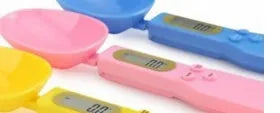 White digital kitchen spoon scale with LCD display showing weight measurement