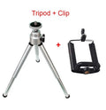 Mini aluminium tripod extended with ball head, shown alongside a U-shaped smartphone clip on a table.