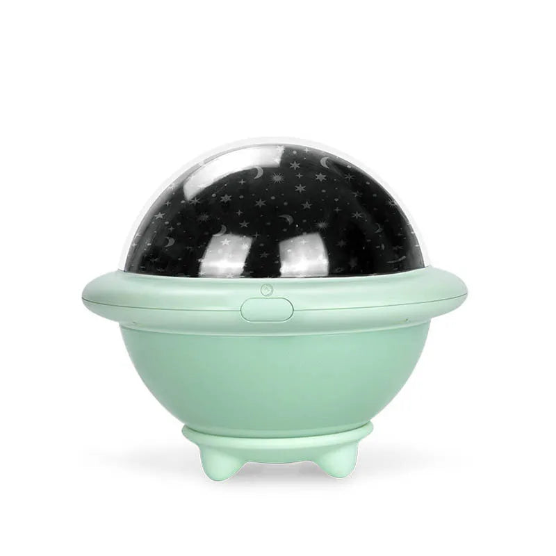 Green UFO-shaped plastic night light projecting a starry sky pattern onto a surface.