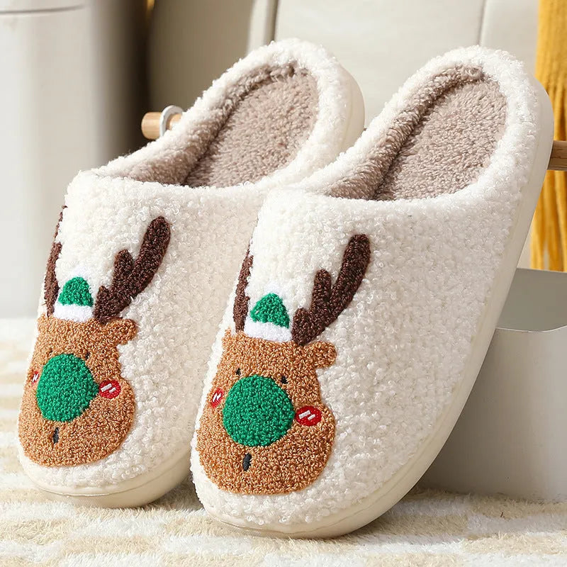 Christmas winter home slippers in red with plush upper and anti-slip sole on a wooden floor