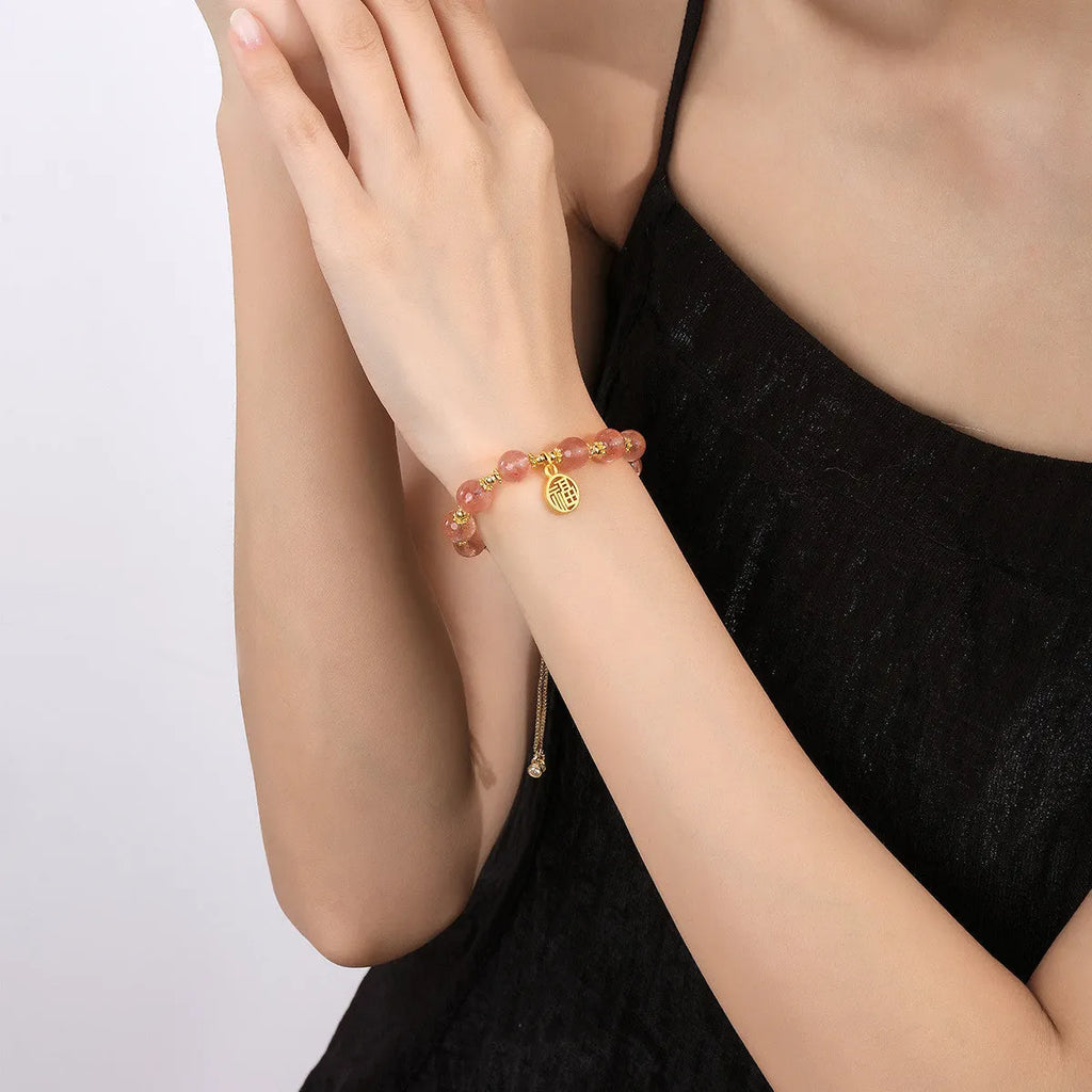 Women's Strawberry Quartz crystal bracelet with geometric shape and fu character design on an electroplated chain.