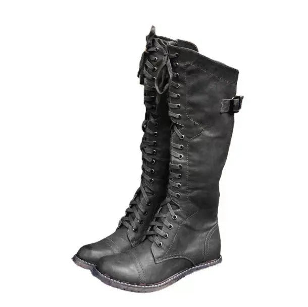 Black women's high-leg boot with a chunky low heel and round toe on a plain background.