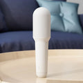 White wireless karaoke microphone with built-in speaker and metal mesh grille on a plain background
