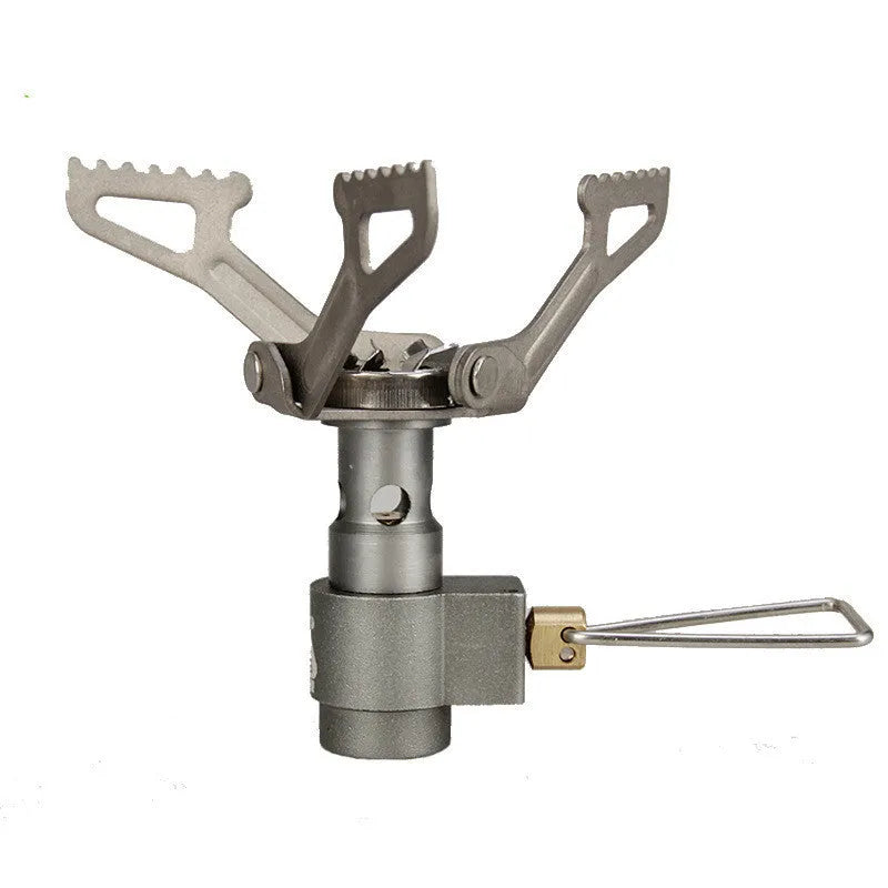 Compact one-piece propane camping stove on a rocky outdoor surface.