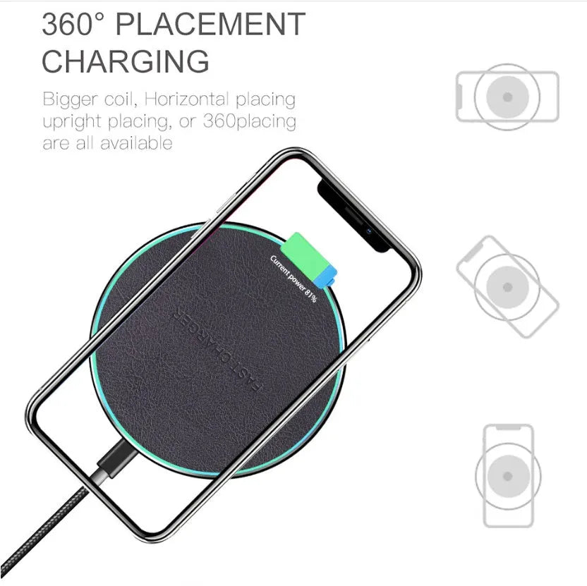 Black circular Qi wireless charging pad for iPhone 11 on a desk.
