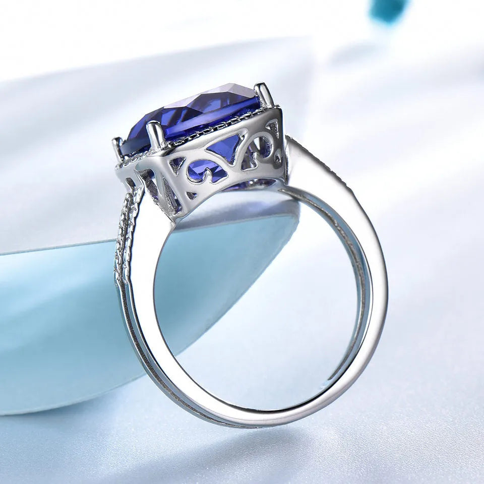 Women's sterling silver ring with a blue tanzanite gemstone on a silver band.