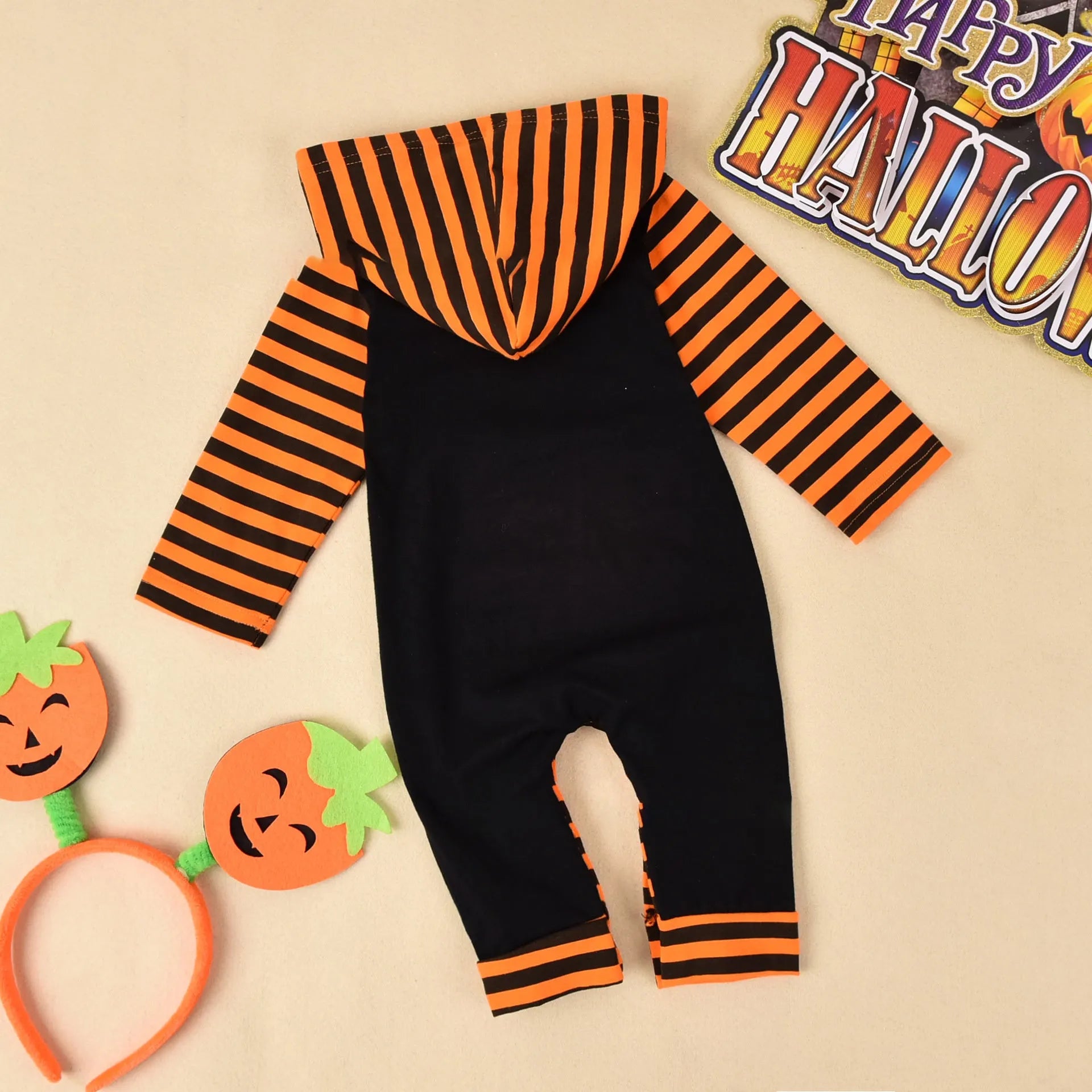 Black cotton hooded Halloween romper for children with long sleeves on a hanger