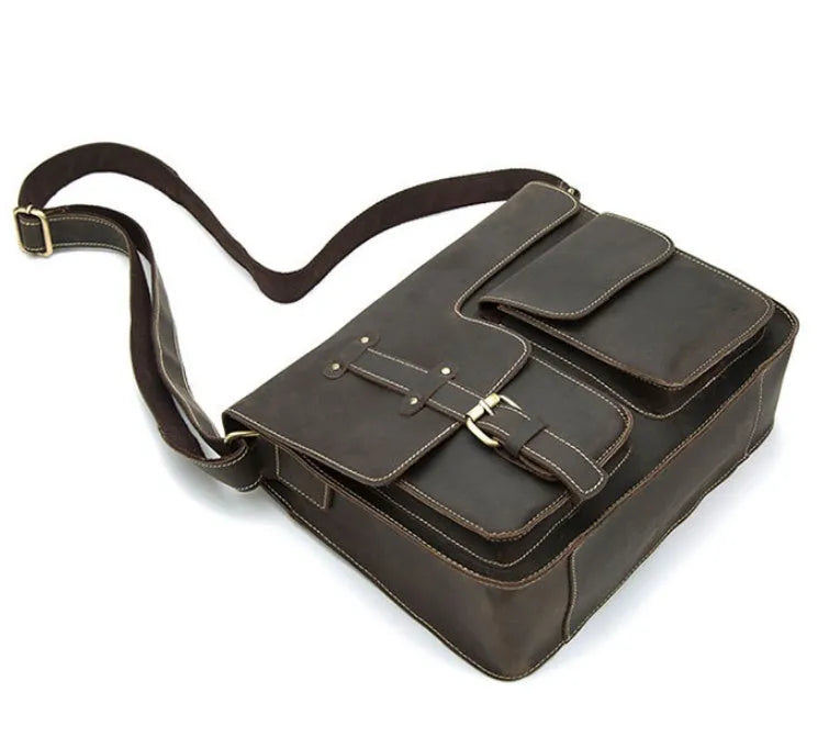 Brown genuine leather vintage messenger bag with adjustable strap, shown open to reveal internal zippered and padded pockets.
