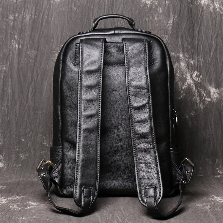 Men's black first layer cowhide leather travel backpack with multiple zipper pockets and top handles, 30cm by 42cm.