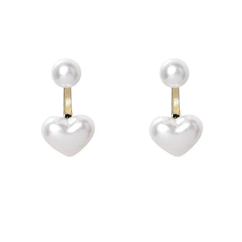Close-up of women's heart-shaped alloy stud earrings with inlaid pearl-like artificial gems on a white background.