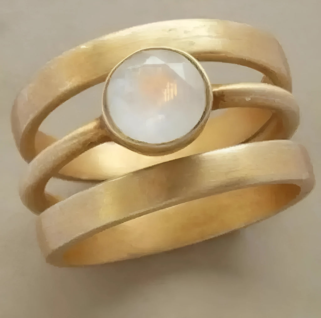 Gold-plated titanium steel geometric ring with a micro-inlaid white chalcedony stone.