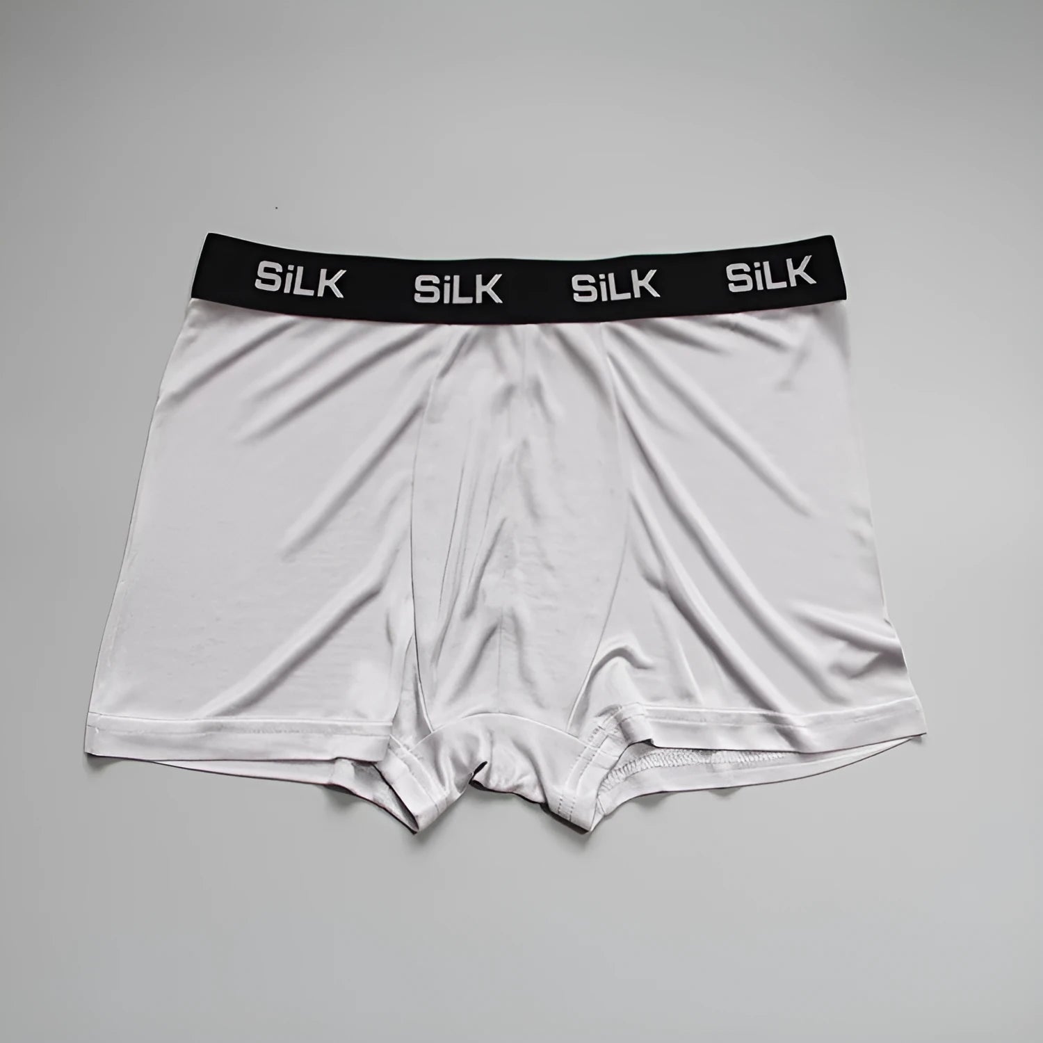Men's loose fit silk shorts in navy blue on a mannequin, showing mid-waist design.