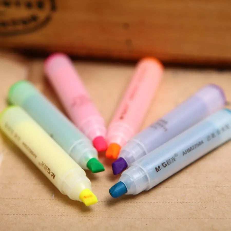 Set of six oblique highlighter pens with plastic shells in assorted colours, presented in a bag.