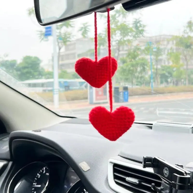 Green and white crocheted wool car plant decoration with a white hanging rope.