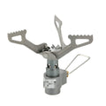 Compact one-piece propane camping stove on a rocky outdoor surface.