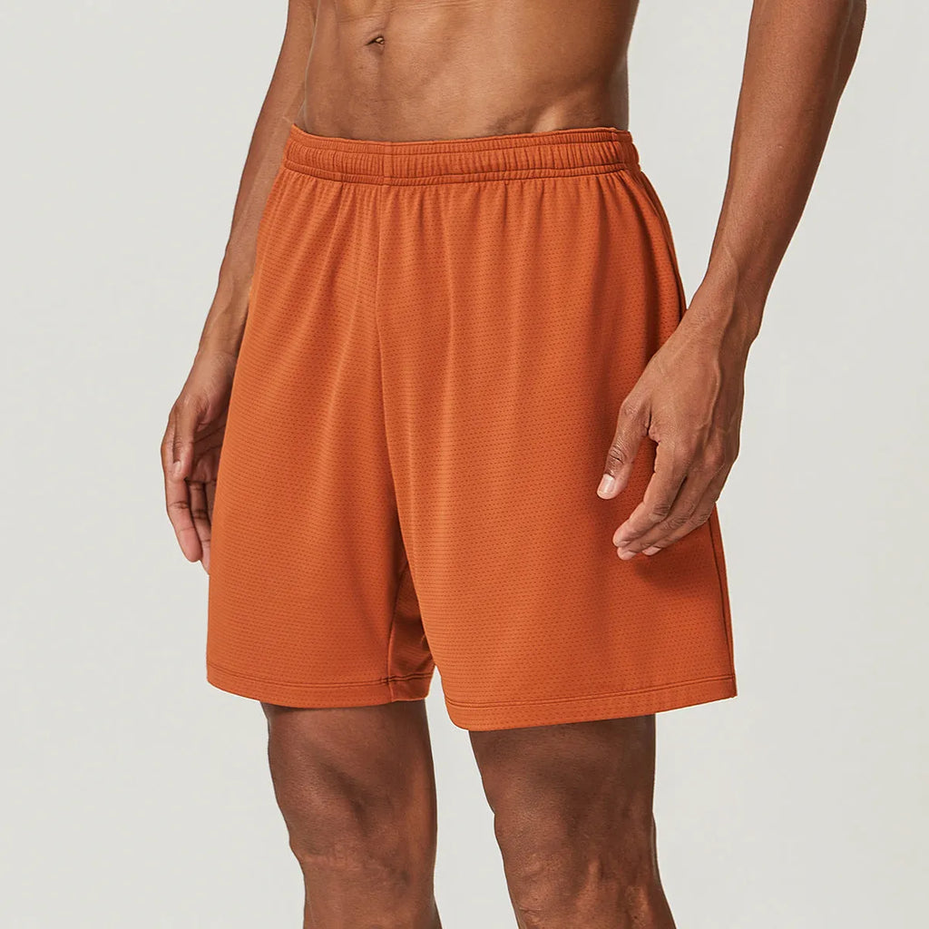 Man wearing brick red double-layer running shorts with a moisture-wicking fabric and inner compression liner.