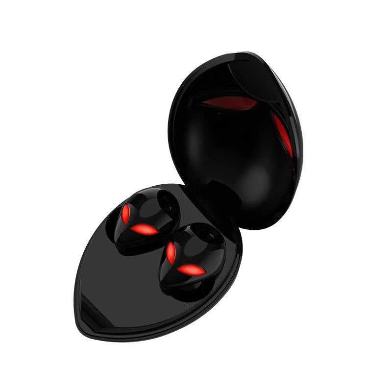 Creative Outer T8 Starman alien-shaped Bluetooth earbuds with LED lights next to their wireless charging case.