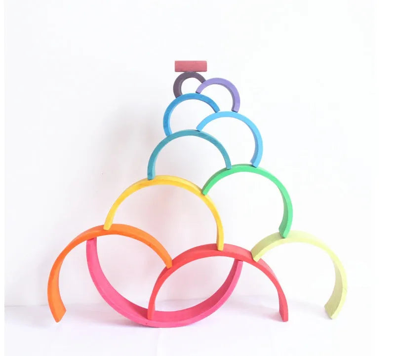 12-piece wooden arch bridge rainbow building blocks made from New Zealand pine with light lacquer finish on a flat surface