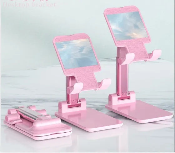 Black adjustable desk mobile phone holder with silicone base on a wooden desk.