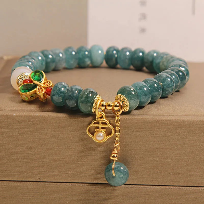 Blue water jade and white agate abacus bead bracelet with alloy inlay, rhinestones, and butterfly charm.