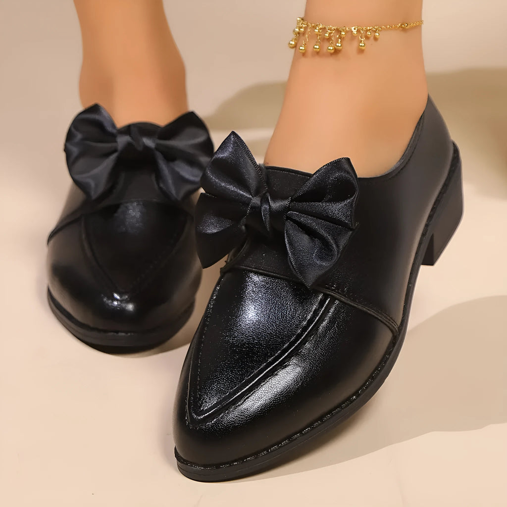 Women's simple leather-look shoes with a decorative bow, on a rubber sole.