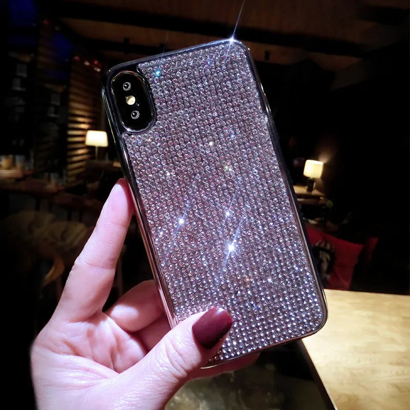 Silver full diamond glitter silicone protective case for iPhone on a table.