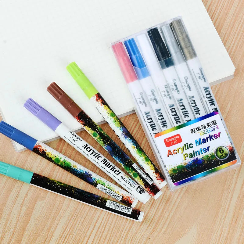 Set of six colourful acrylic marker pens with 0.7mm nibs in a plastic storage box.