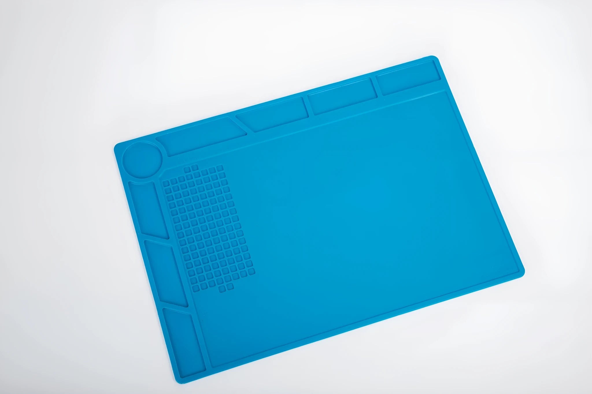 Blue silicone watch repair mat with non-slip surface for component organisation during watch work