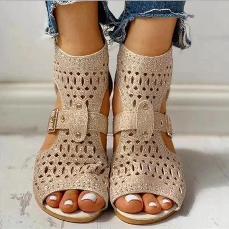 Beige women's flat sandals with a back zipper, fish mouth toe, and low wedge heel on a white background.