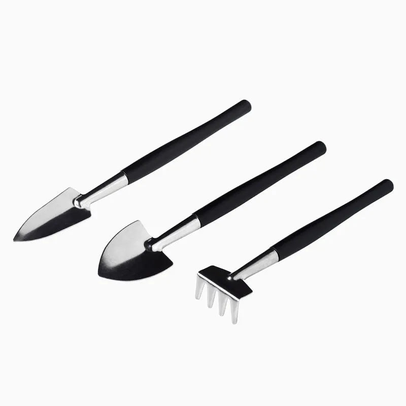 Black plastic and metal mini garden tool set with 16 pieces including small shovel, tweezers, scissors, and a grey kneeling cushion.