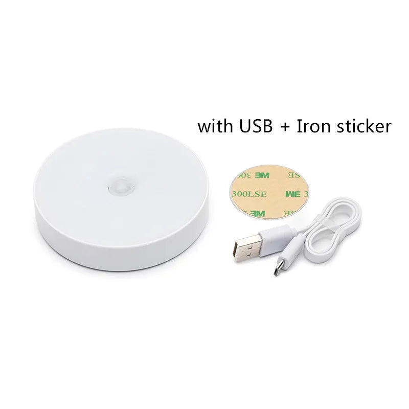 Small round white motion sensor night light with USB charging cable and adhesive tape.