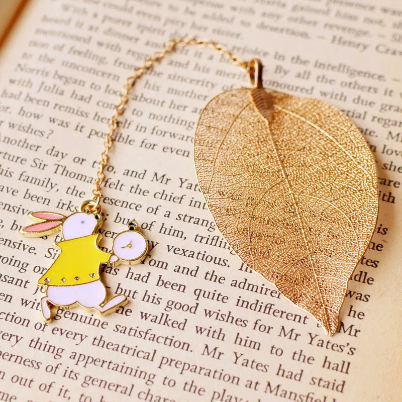 KC alloy bookmark with Alice, rabbit, clock, and leaf charms on kraft packaging