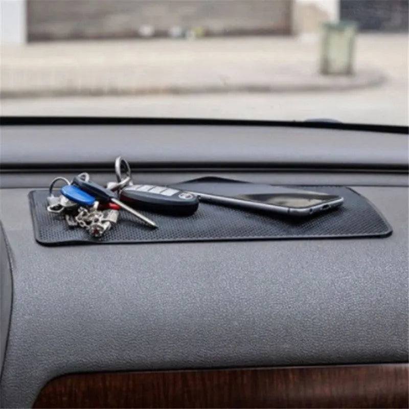 Black mesh car dashboard non-slip mat, 18x13cm, 60g, holding small items like phone, coins and glasses.