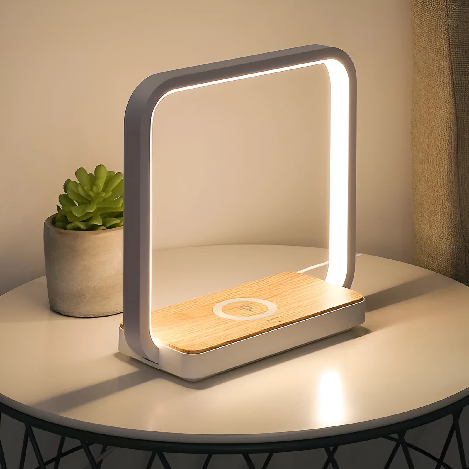 Modern white aluminium smart bedside lamp with touch control and USB cable on a wooden table.