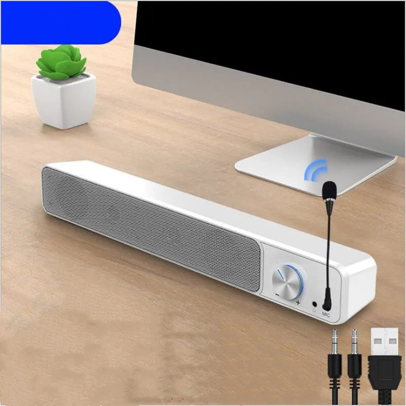 Black and white G18 compact desktop computer speaker with USB cable on a wooden desk.
