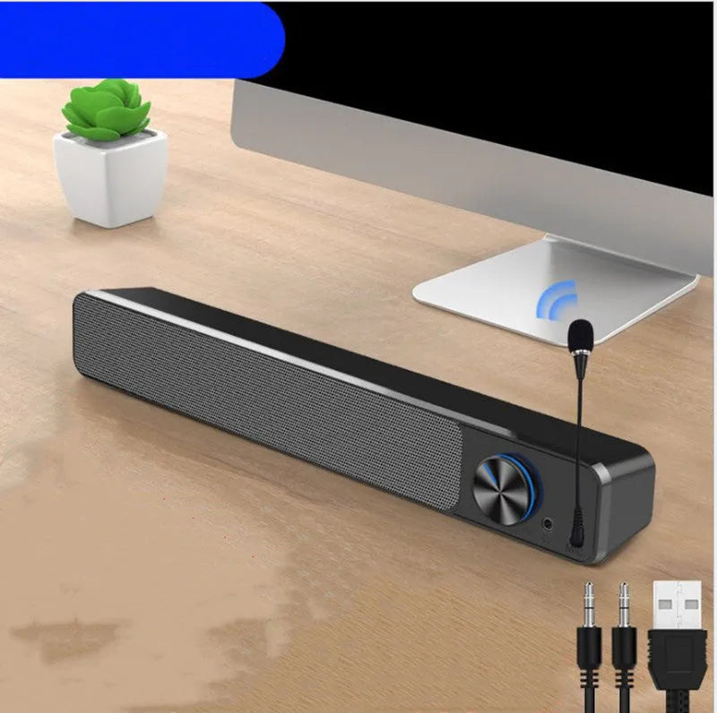 Black and white G18 compact desktop computer speaker with USB cable on a wooden desk.