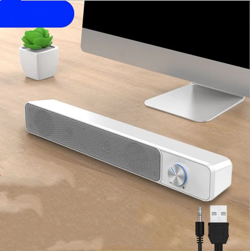 Black and white G18 compact desktop computer speaker with USB cable on a wooden desk.