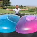 Large colourful inflatable bouncy ball in pink, yellow, green, and blue, shown in various sizes for children's play.