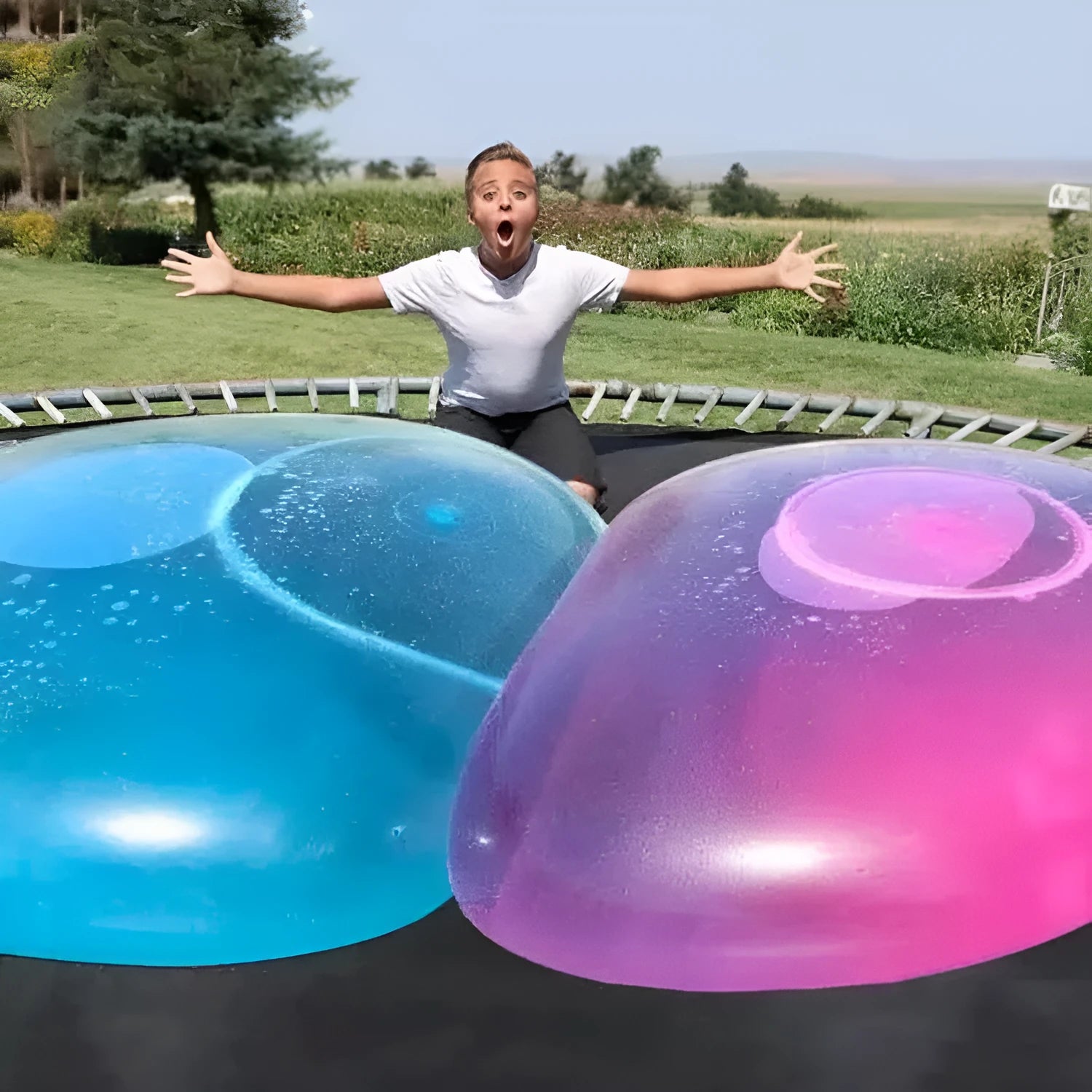 Large colourful inflatable bouncy ball in pink, yellow, green, and blue, shown in various sizes for children's play.