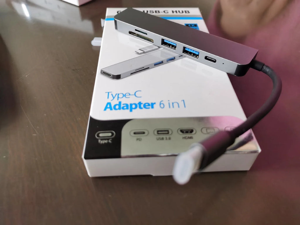 Silver 6 in 1 USB C hub adapter with USB ports, SD/TF slots, HDMI, and PD charging port