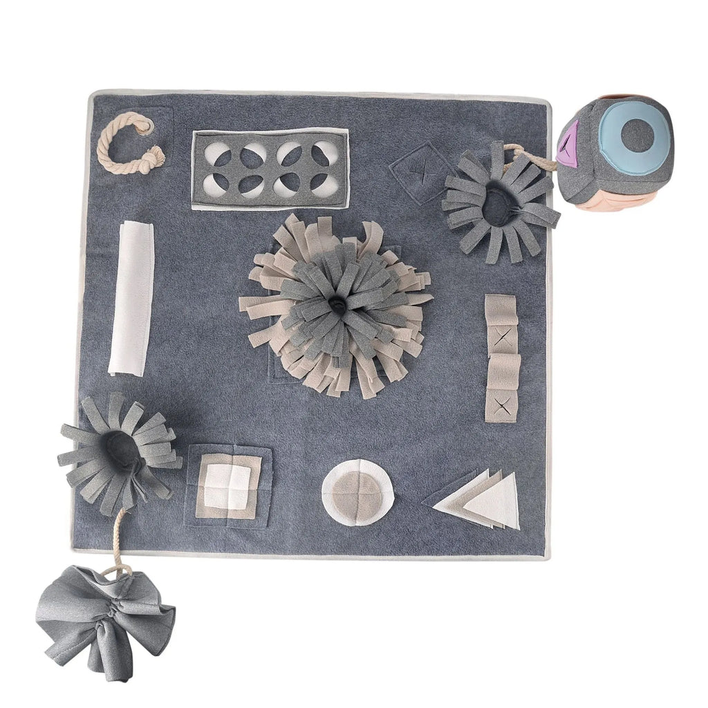 Grey cloth pet sniffing pad with two snuffle toys on a surface, designed for dog foraging and stress relief