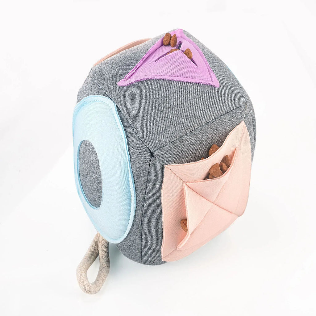 Grey cloth pet sniffing pad with two snuffle toys on a surface, designed for dog foraging and stress relief