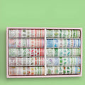 100 rolls of hand account tape in antique and cute designs organised in cardboard storage box