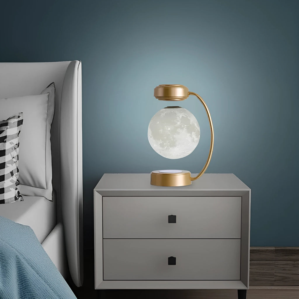 Black magnetic levitation moon lamp floating above base with golden LED illumination