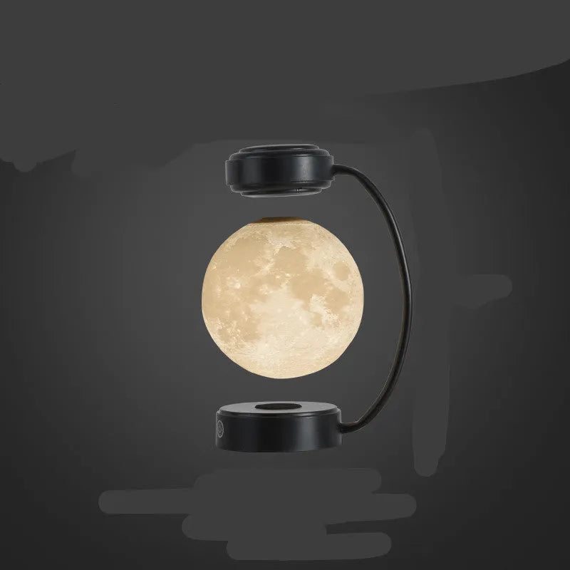 Black magnetic levitation moon lamp floating above base with golden LED illumination