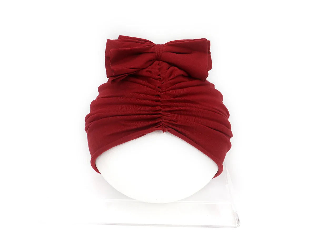 Soft acrylic knitted turban-style baby hat for newborn to 28-month infants in solid candy colours