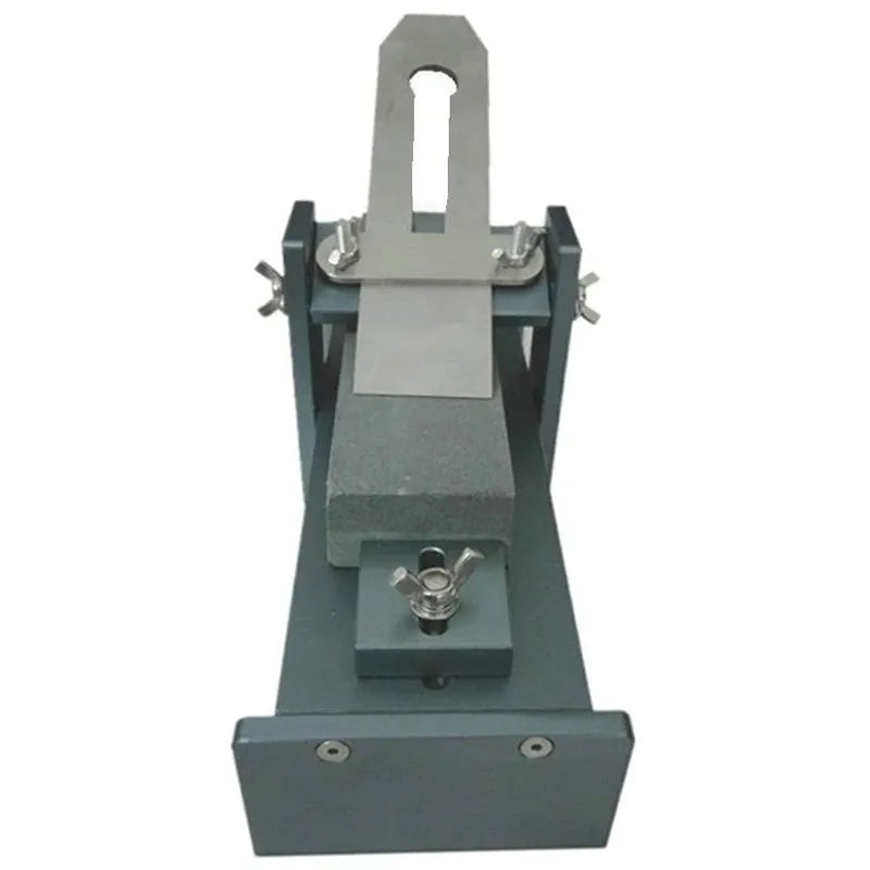 Aluminium fixed angle sharpening tool for woodworking chisels and planer blades on a workbench.